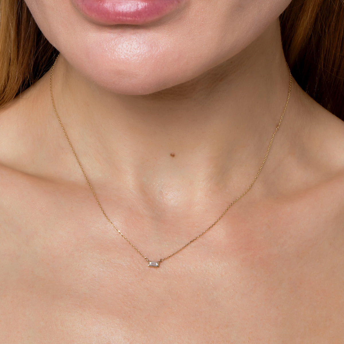BAGUETTE DIAMOND BEZEL NECKLACE-Necklaces-A single baguette diamond is set in a gold bezel setting on a delicate chain. - available in 14k yellow and white gold - diamond: approximately 0.10 carat total weight; G-H color, SI clarity - triple extendable chain; 14” - 15” - 16” - lobster clasp - shown on model in yellow gold - custom size diamond available: ice@anneauxjewelry.com-Anneaux Jewelry