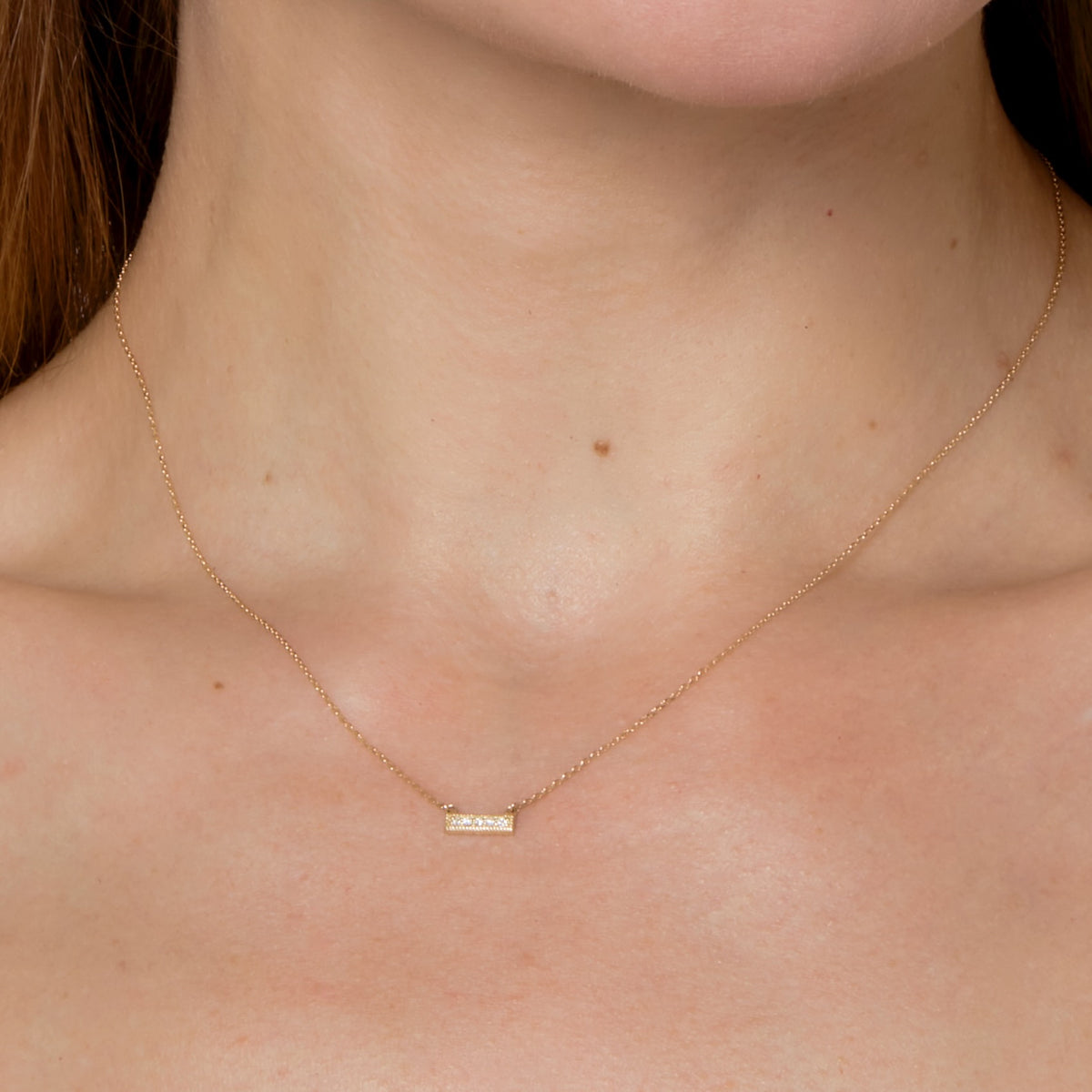 DIAMOND BAR NECKLACE-Necklaces-Five diamonds sit across a 14K solid gold bar with milgrain trim and attached to a diamond cut cable link chain. This everyday accessory knows how to "raise the bar." - available in 14k yellow and white gold - diamonds: approximately 0.04 total carat weight, G-H color, SI clarity - triple extendable chain; 14” - 15” - 16” length - lobster clasp - shown on model in yellow gold-Anneaux Jewelry