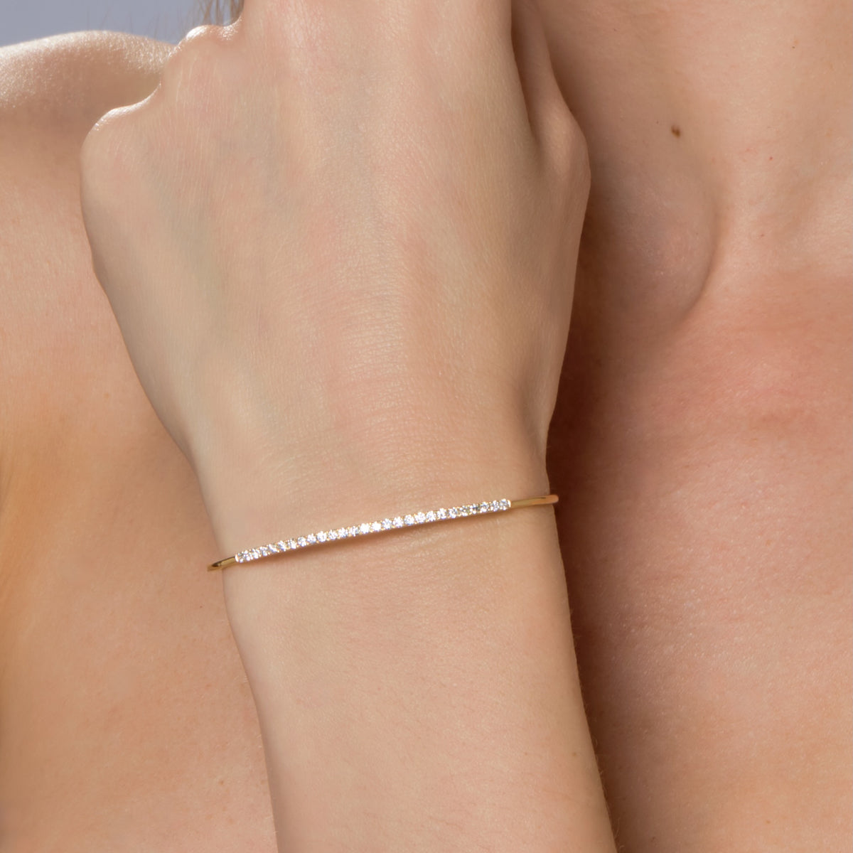 DIAMOND ROW BANGLE-Bangle-A row of diamonds sits atop this yellow gold wire bangle, wear alone or add to your wrist stack. - available in 18k yellow and white gold - 60 x 50 mm - diamonds: approximately 0.60 total carat weight; G-H color; SI clarity - shown on model in yellow gold-Anneaux Jewelry
