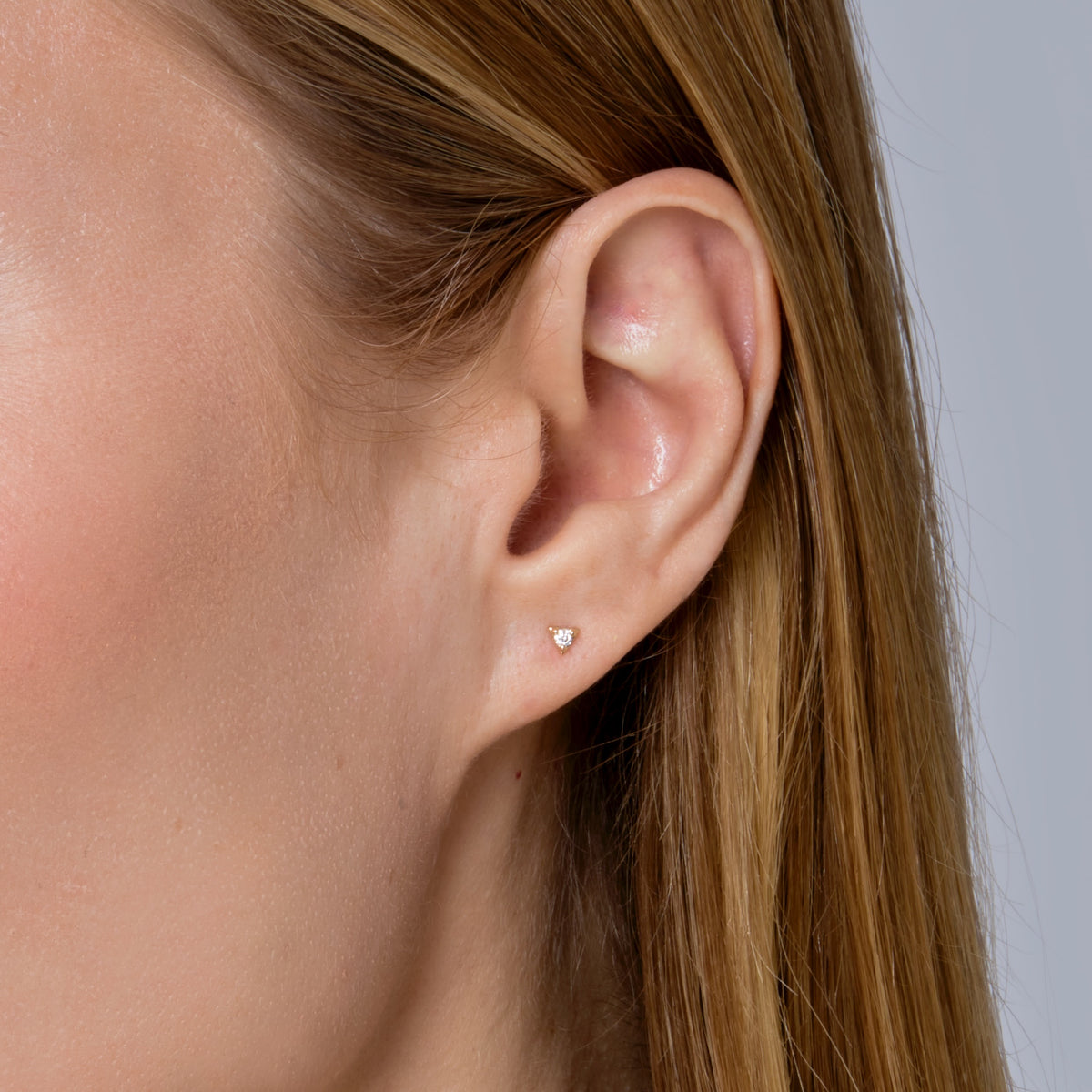 DIAMOND IN TRIANGLE STUD-Studs-The center of this 18k solid gold triangle is set with a single round diamond for a sparkly pop. - Available in 18k yellow or white gold - diamond in single stud: approximately 0.03 total carat weight; G-H color, SI 1-2 clarity - comfort fit silicone backing - shown on model in yellow gold-Anneaux Jewelry