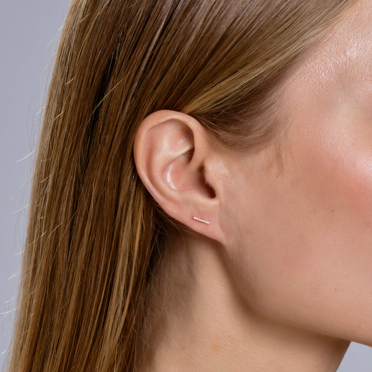 SEVEN DIAMOND BAR STUD-Studs-Diamond bars complete an earring stack. This one has a row of seven diamonds in 14k solid gold. - available in 14k yellow, white and rose gold - diamonds in single stud: approximately 0.05 total carat weight, G-H color, SI clarity - 14K solid gold butterfly backing - shown on model in yellow gold-Anneaux Jewelry